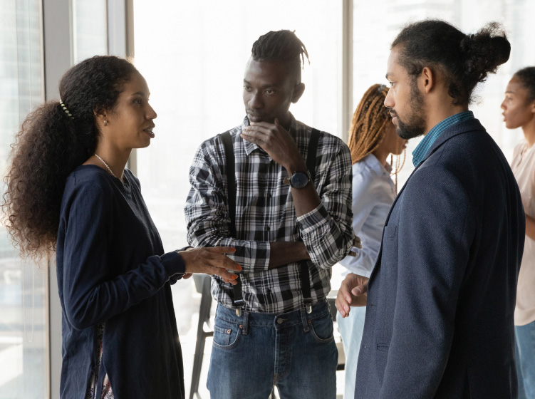 African American colleagues chatting, sharing ideas, standing in office stock photo